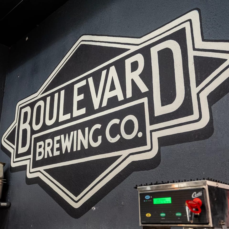 A large white and black Boulevard Brewing Co. logo painted on a dark gray wall.